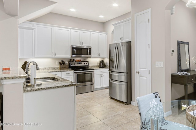 kitchen featuring sink, stainless steel appliances, light stone counters, white cabinets, and light tile patterned flooring