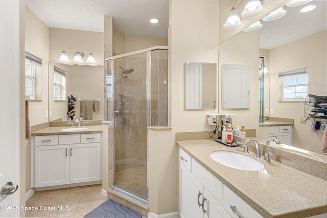 bathroom featuring vanity, tile patterned flooring, a textured ceiling, and walk in shower