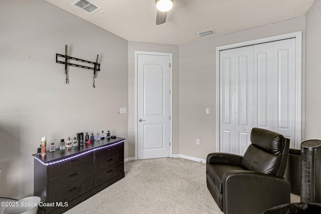 living area featuring light colored carpet and ceiling fan