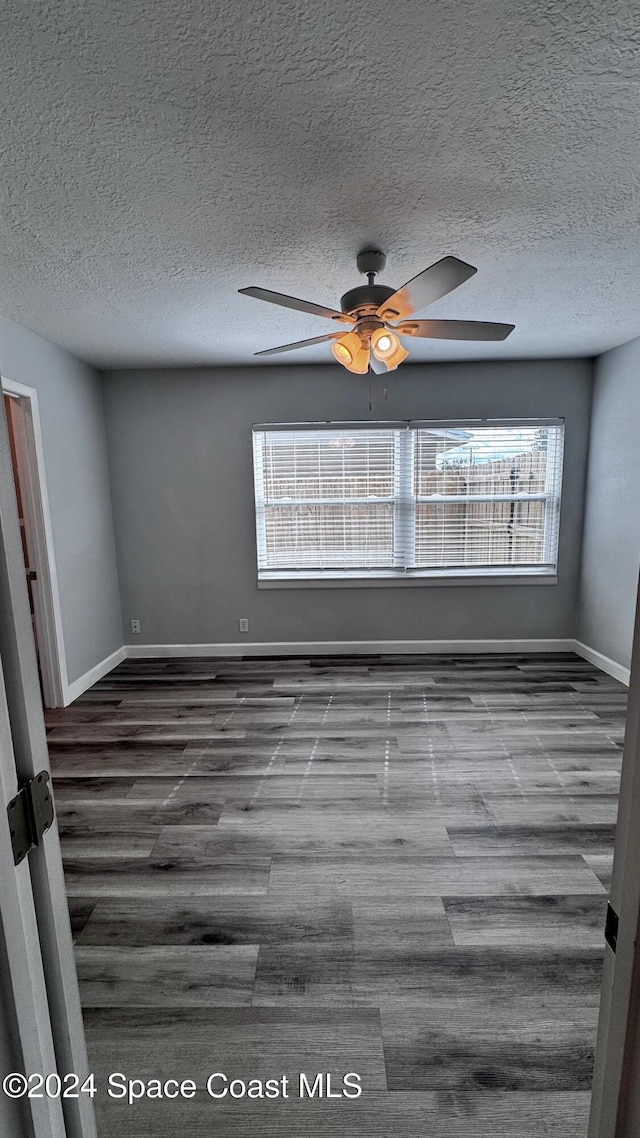 spare room with ceiling fan, wood-type flooring, and a textured ceiling