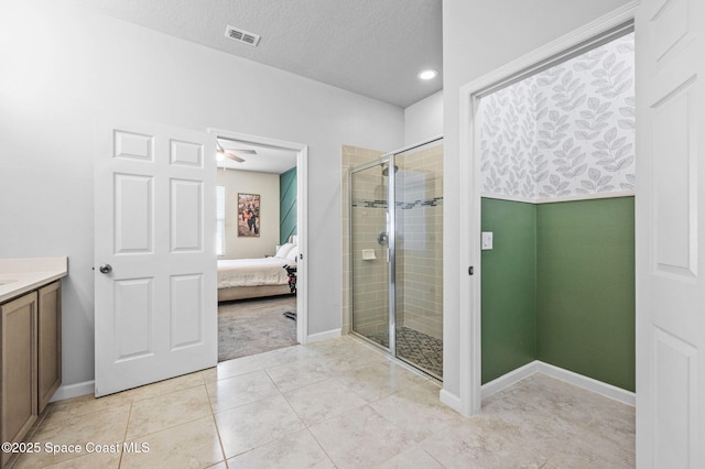 bathroom with vanity, tile patterned flooring, a textured ceiling, and walk in shower