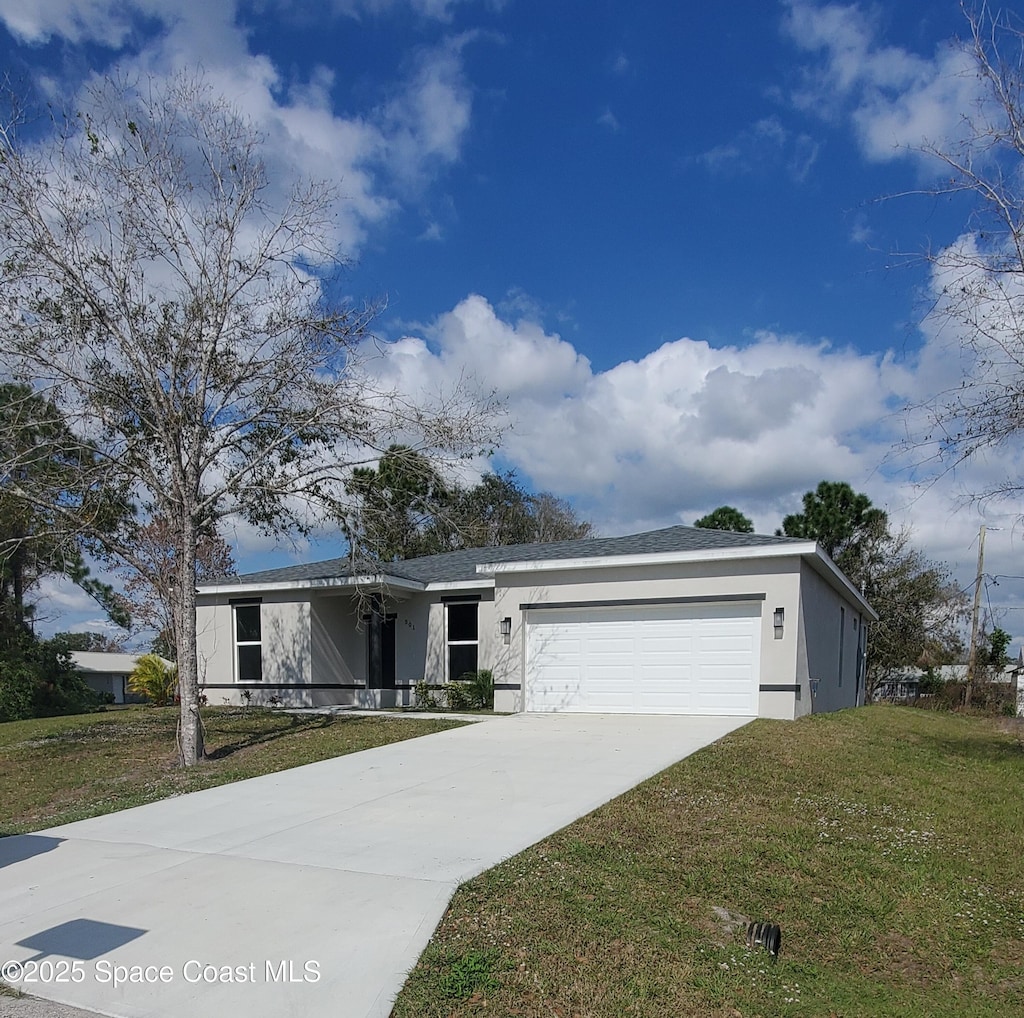 view of front of house with a garage and a front lawn