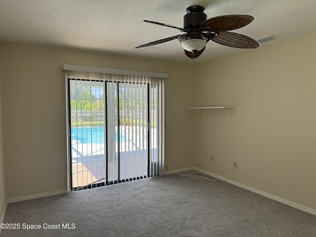 carpeted spare room featuring ceiling fan and a textured ceiling