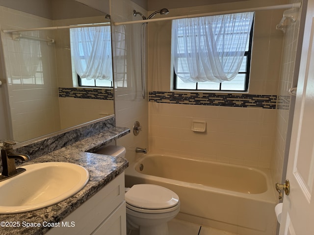 full bathroom featuring vanity, tiled shower / bath, tile patterned flooring, and toilet