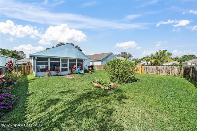 view of yard with a fenced backyard and a sunroom