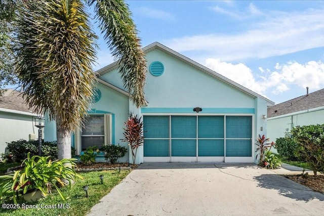 view of front of home with a garage, concrete driveway, and stucco siding