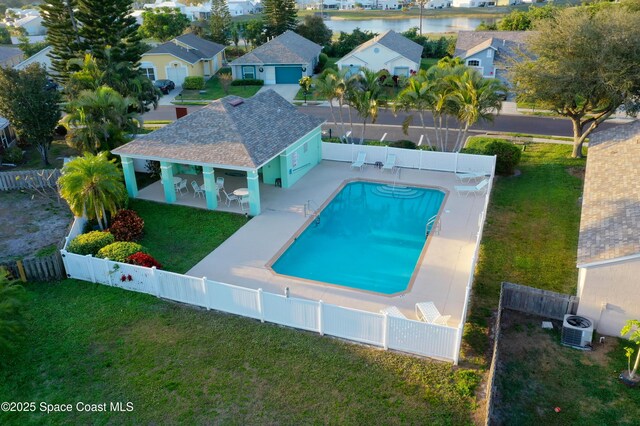 view of pool featuring cooling unit, a fenced backyard, a yard, a residential view, and a fenced in pool