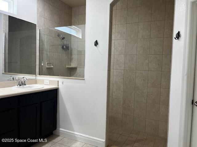 bathroom with vanity, a tile shower, and tile patterned floors