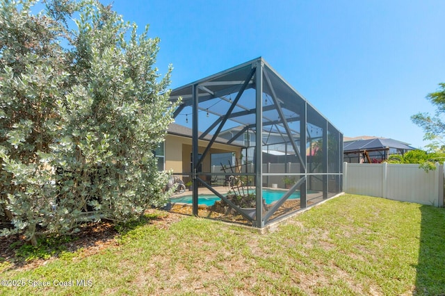 back of house with a fenced in pool, a lanai, and a lawn