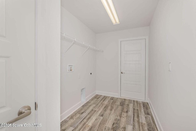 clothes washing area with hookup for a washing machine, electric dryer hookup, and light hardwood / wood-style flooring