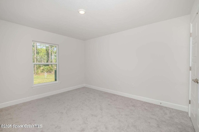 carpeted spare room with baseboards