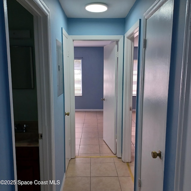 corridor featuring electric panel and light tile patterned floors