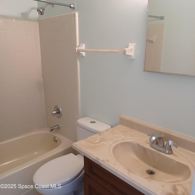 full bathroom with vanity, tiled shower / bath combo, and toilet