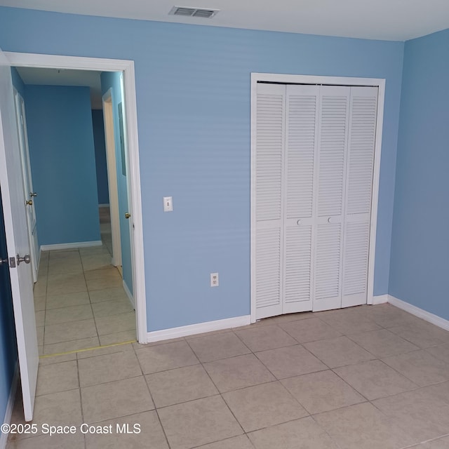 unfurnished bedroom featuring a closet and light tile patterned flooring