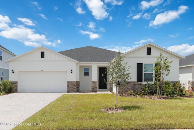 416 Glaspell Cir SE, Palm Bay, FL 32909 - view of front of home featuring stone siding, board and batten siding, an attached garage, and a front yard
