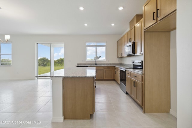 416 Glaspell Cir SE, Palm Bay, FL 32909 - kitchen with appliances with stainless steel finishes, a center island, light stone counters, recessed lighting, and light tile patterned flooring