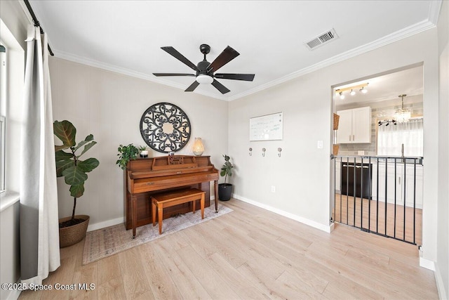 sitting room featuring baseboards, visible vents, ceiling fan, ornamental molding, and light wood-type flooring