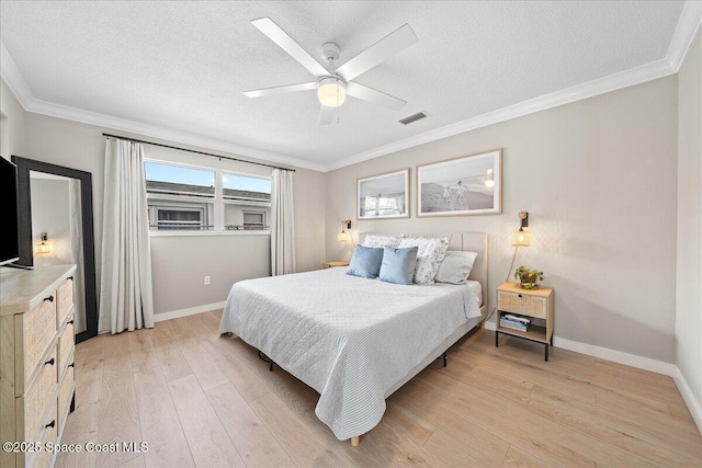 bedroom with light wood-style floors, visible vents, and a textured ceiling