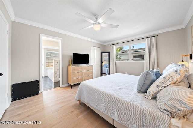 bedroom with light wood-type flooring, crown molding, and a textured ceiling