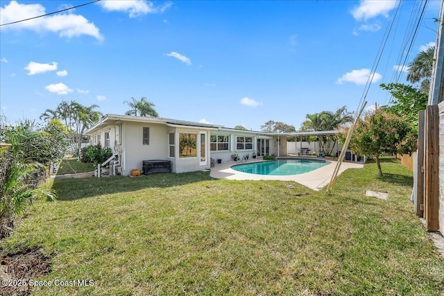 back of property with a yard, stucco siding, a patio area, a fenced backyard, and an outdoor pool