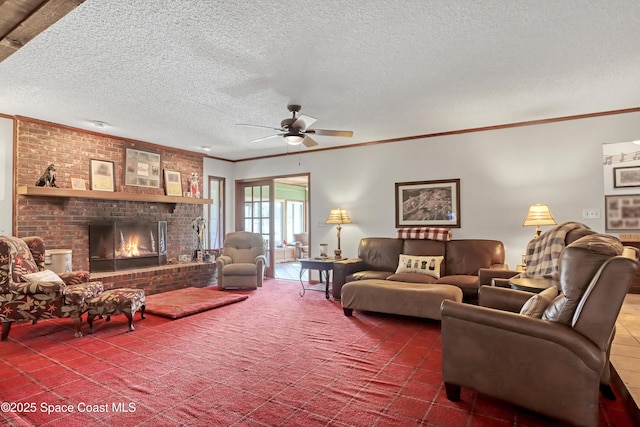 living room featuring ceiling fan, crown molding, a fireplace, and a textured ceiling