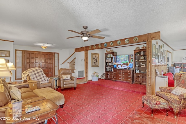 living room featuring ceiling fan and a textured ceiling