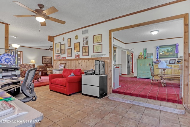 tiled home office with ceiling fan, crown molding, a textured ceiling, and wood walls