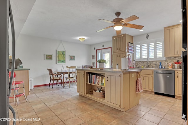 kitchen featuring sink, light tile patterned floors, appliances with stainless steel finishes, backsplash, and a center island