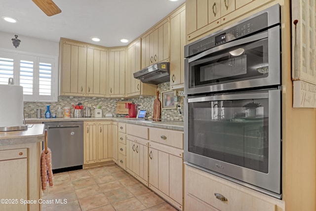 kitchen featuring light brown cabinetry, light tile patterned floors, decorative backsplash, and stainless steel appliances