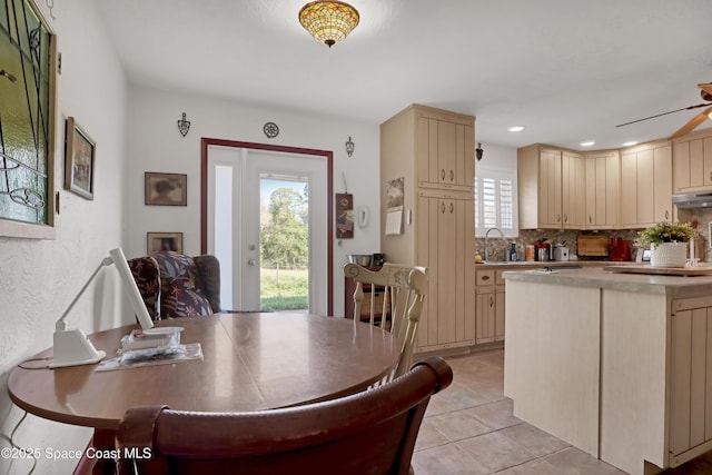 kitchen with light tile patterned floors, sink, ceiling fan, backsplash, and light brown cabinetry