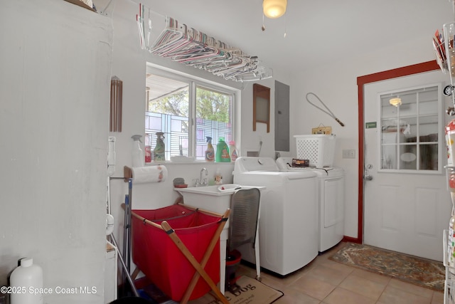 laundry area featuring electric panel, washer and dryer, and light tile patterned floors