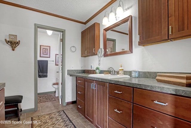 bathroom with tile patterned floors, toilet, a textured ceiling, ornamental molding, and vanity