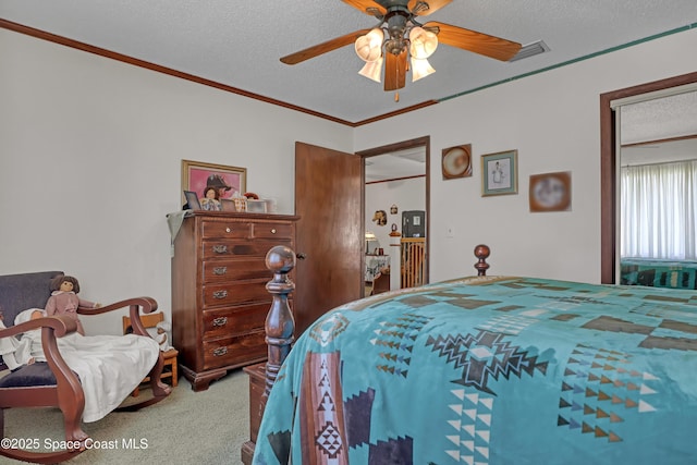 carpeted bedroom featuring ceiling fan, crown molding, and a textured ceiling