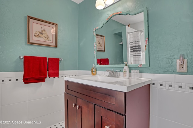 bathroom with vanity and tile walls