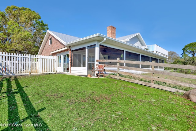 back of house featuring a sunroom and a yard