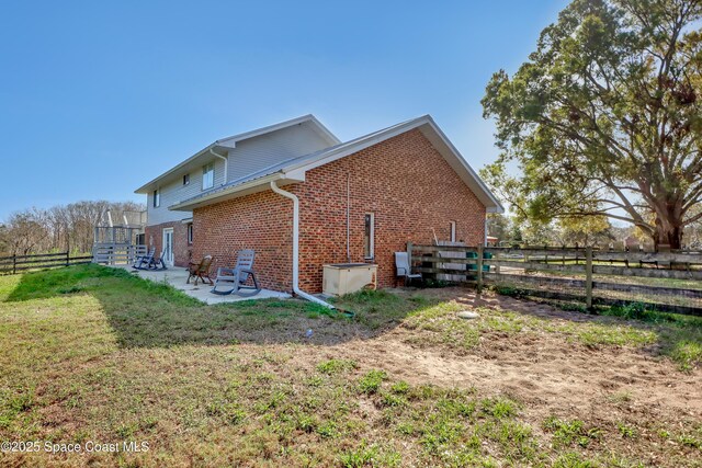 view of side of property with a yard and a patio area