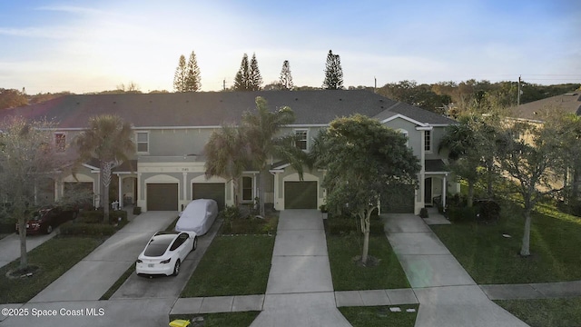 view of front facade featuring a garage, concrete driveway, and a yard