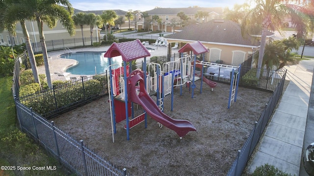 communal playground with a community pool and fence