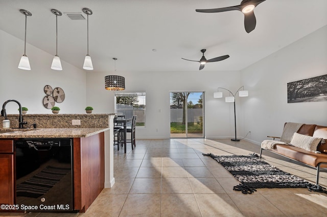 living area featuring light tile patterned floors, visible vents, a ceiling fan, and baseboards