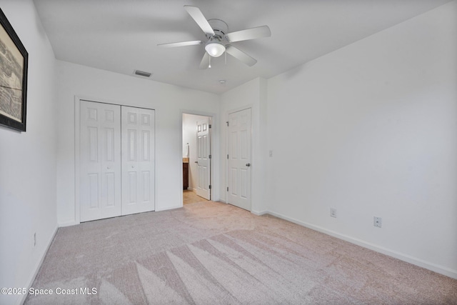 unfurnished bedroom featuring light carpet, a ceiling fan, visible vents, and baseboards