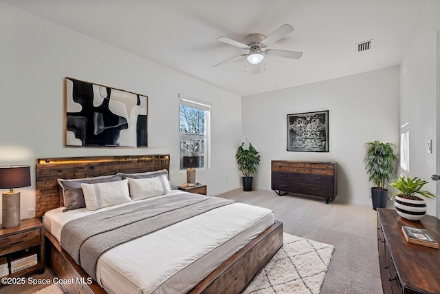 bedroom with a ceiling fan, light carpet, visible vents, and baseboards