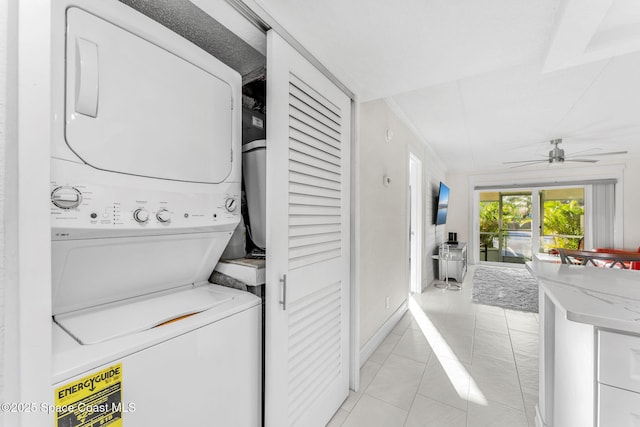 laundry room featuring ceiling fan, stacked washer and dryer, and light tile patterned floors