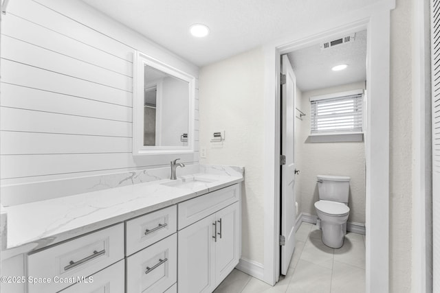 bathroom with vanity, tile patterned floors, and toilet