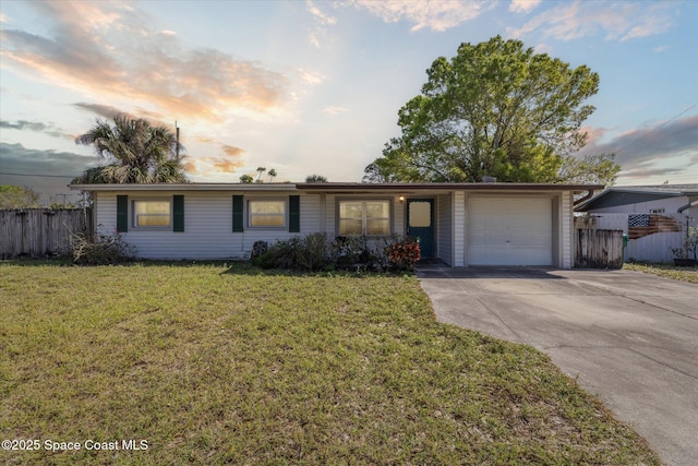 ranch-style home with a garage, concrete driveway, a front yard, and fence