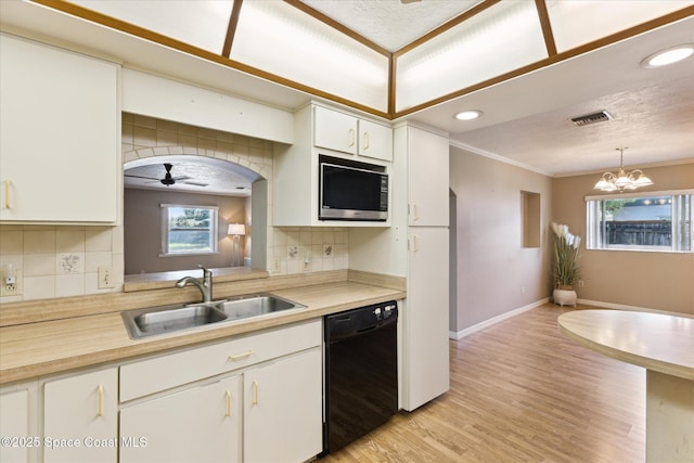 kitchen featuring dishwasher, light countertops, white cabinetry, pendant lighting, and a sink