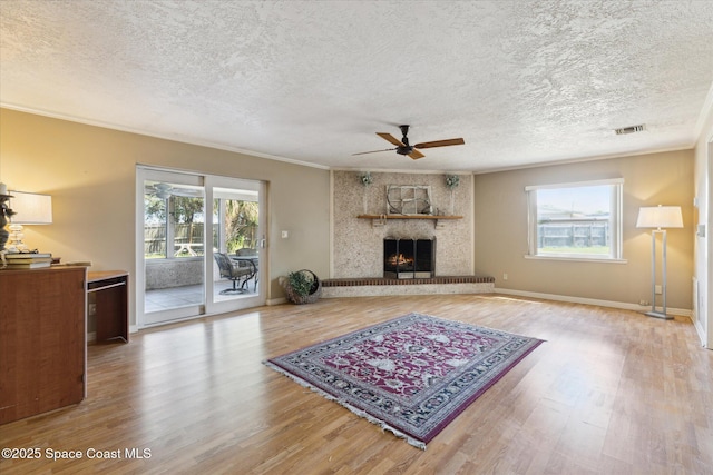 living area with a healthy amount of sunlight, visible vents, and wood finished floors