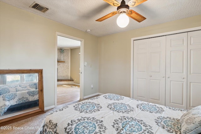 bedroom featuring a closet, visible vents, a ceiling fan, a textured ceiling, and baseboards