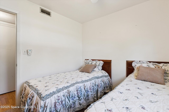 bedroom featuring visible vents and wood finished floors