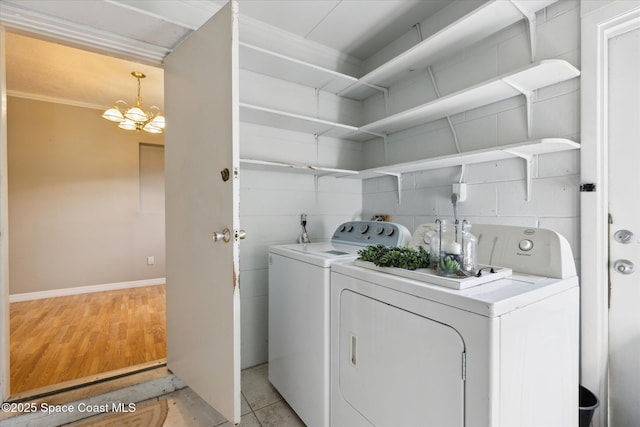 laundry room with laundry area, a chandelier, light wood-style floors, and washing machine and clothes dryer