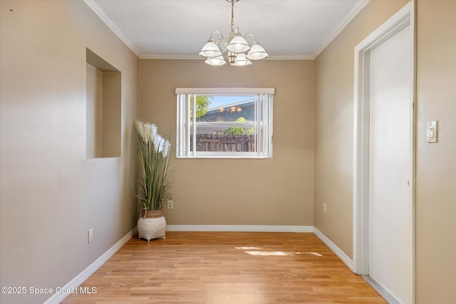 unfurnished dining area featuring light wood-type flooring, baseboards, and crown molding